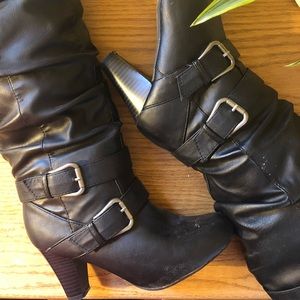 Black high heel boots with silver buckles.